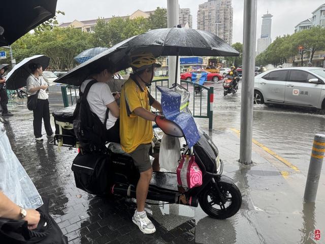 浦东遭遇暴雨，市政工人全力排水，外卖小哥“摆渡”市民过街