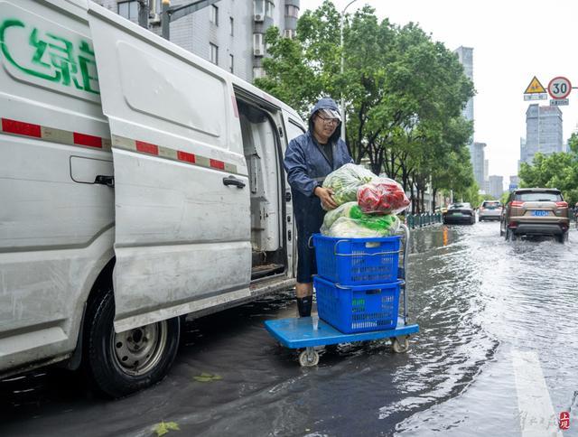 浦东遭遇暴雨，市政工人全力排水，外卖小哥“摆渡”市民过街