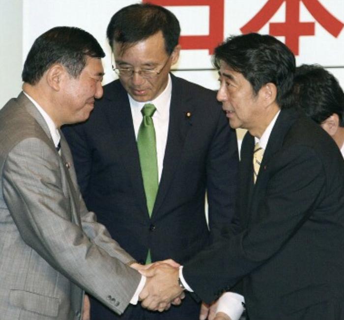 输给安倍(右)的石破茂(左)与对方握手。(图源:社交媒体)