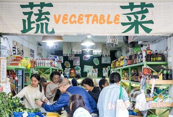 图说:街巷小店改造官找到蔬菜店老板,提出公益改造计划,将老板娘女儿的画融入装饰