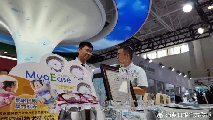 图为消费者在展会上选购离焦眼镜。