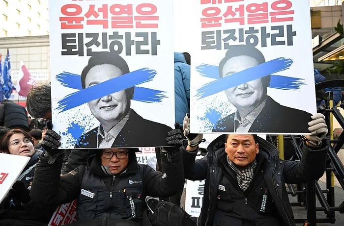 当地时间12月6日,韩国首尔, 韩国民众举着尹锡悦标牌,呼吁弹劾总统。图/视觉中国