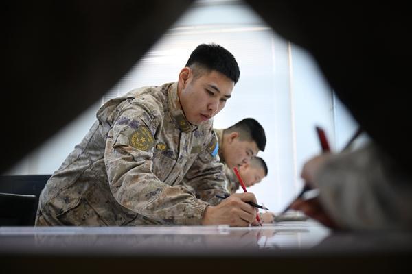官兵正在进行人工标图训练,通过保底手段提升应急作战能力。