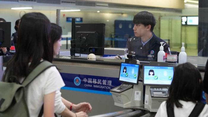 虹桥边检站民警为旅客办理通关手续。王伊洁 摄