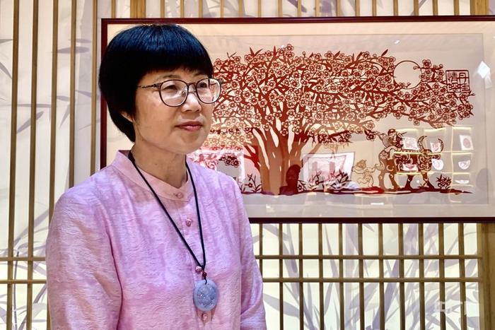 浦城剪纸国家级非遗传承人周冬梅向记者介绍其代表作《丹桂情深》(央广网记者 罗晓英 摄)