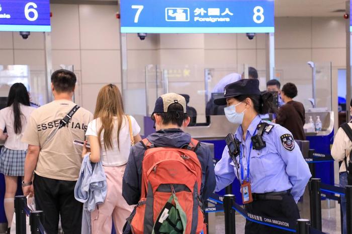 5月3日,无锡边检站工作人员在无锡硕放机场边检入境现场引导外籍游客。新华社发(朱吉鹏摄)
