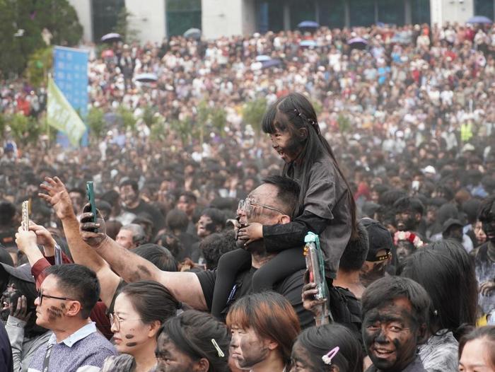 5月2日,游客和当地群众在云南省墨江哈尼族自治县参加“抹黑脸”民俗活动。(墨江县融媒体中心供图)