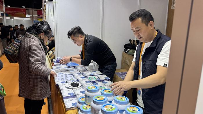 图为展览会现场,游客正在挑选商品。