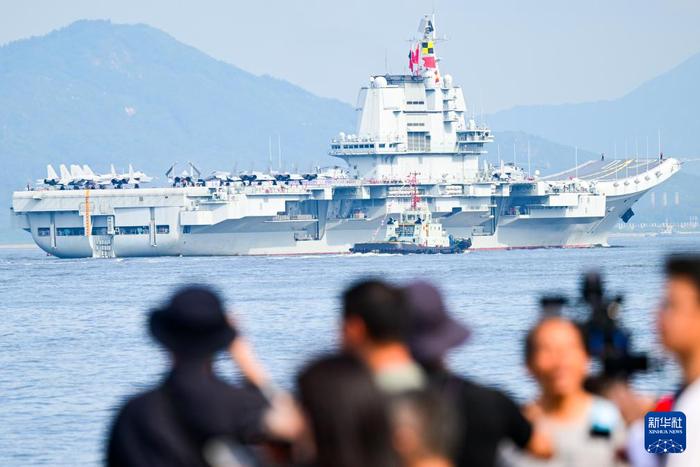 7月3日,人们在岸上拍摄海军山东舰抵达香港。新华社记者 朱炜 摄