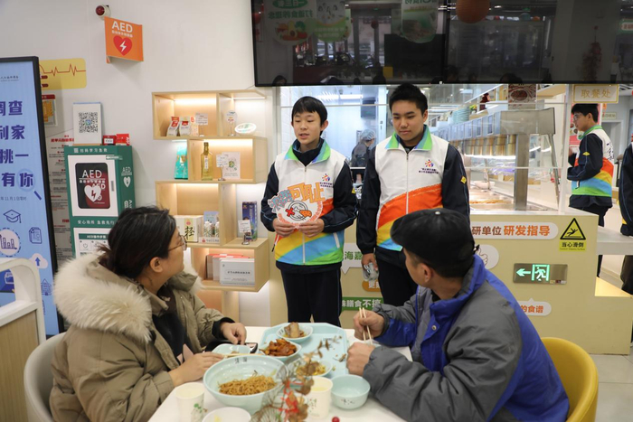 志愿者们向食客宣传节粮反浪费知识。 中国经济网 王岩/摄