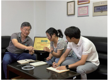 2024年7月,袁广银(左一)和课题组博士生讨论血管支架用微管加工工艺