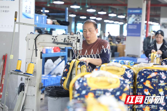 工人们在箱包企业工作。