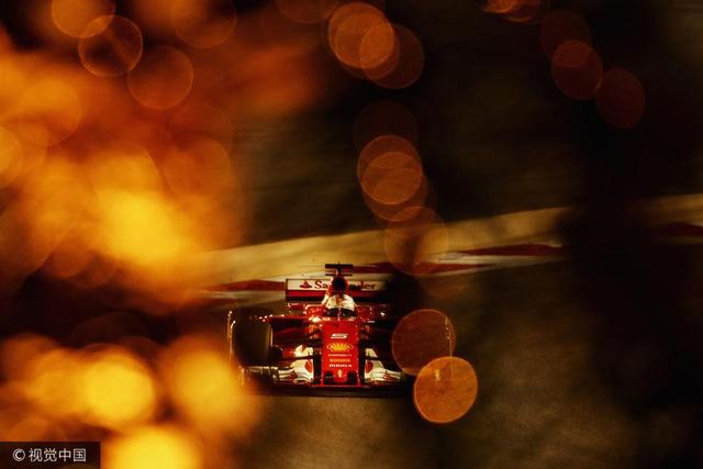 2017年4月15日，巴林，2017 F1世界大奖赛巴林站排位赛。法拉利车队的车手塞巴斯蒂安·维特尔驾驶Scuderia Ferrari SF70H赛车疾驰，夕阳与赛道交相辉映在镜头里呈现了绚烂的光斑。