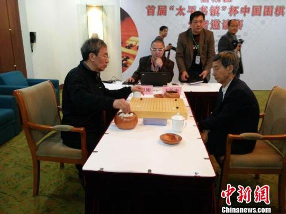 中国围棋协会主席王汝南正在与北京围棋基金会理事长华以刚对弈。　钟升　摄