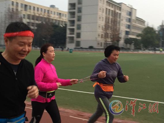 陈明（左）在襄阳跑友帮助下跑步。