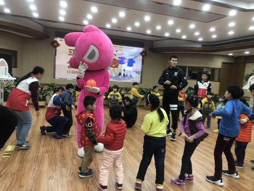 上海东方大鲨鱼篮球俱乐部运动员在指导小朋友做赛前热身训练