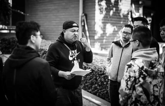 负责数据采集的工作人员(戴帽子男子)现场指导群演做表情