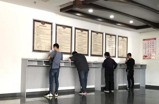 劳动人事争议仲裁院大厅内填材料的人们