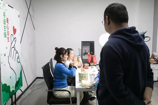 图:沈治克正在旁观妹妹的直播。 摄影| 贺斌
