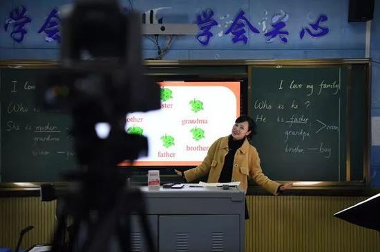 教师在教室内通过摄像头直播网络课程,图源新华网