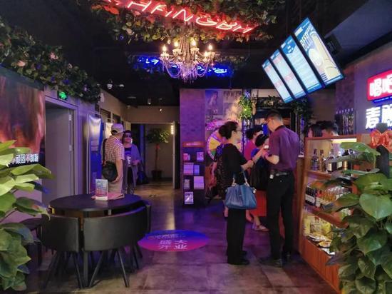 (门店的服务员帮年龄稍大的人进行手机扫码、注册等)