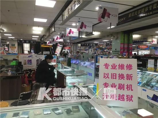 一位手机商无精打采地坐在沙发上玩手机,橱柜里的新款iPhone摞成一叠。