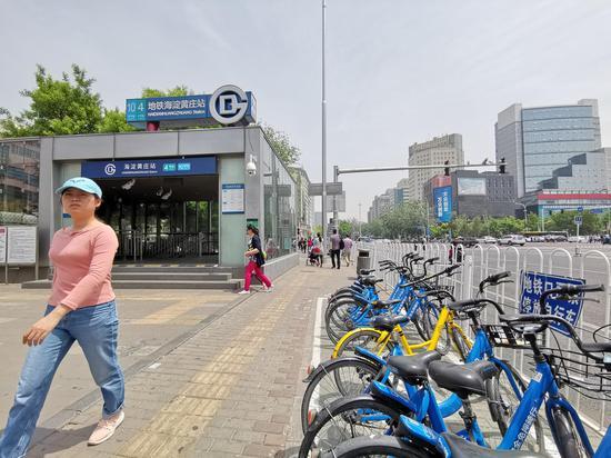 地铁海淀黄庄站外,共享单车整齐的停放在停车区域内,一旁还张贴有“地铁口严禁停放自行车”的宣传标语牌。 新京报记者 王贵彬 摄