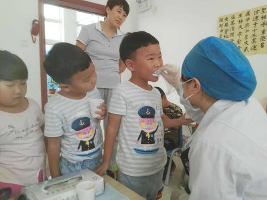 ▲医生正在给儿童牙齿做氟化泡沫