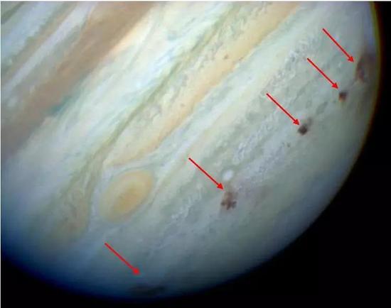 彗木撞击在当时的木星表面留下的“疤痕”(红色箭头处)。来源:NASA