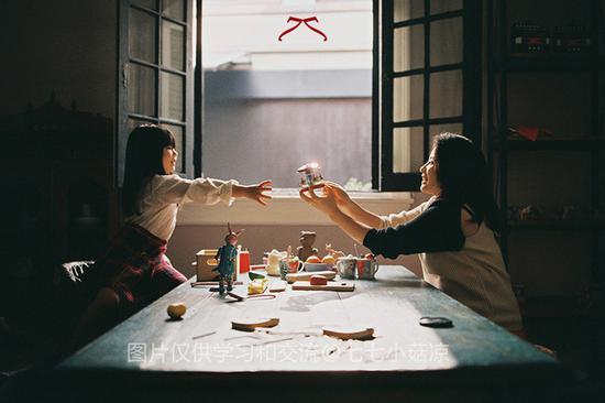 上图:妈妈正把一个闪闪发亮的旋转木马递给女儿。