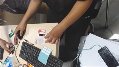 6月15日,一名工作人员正在检验“兼职人员”的身份证、银行卡、U盾。A08-A09版摄影/新京报记者 大路