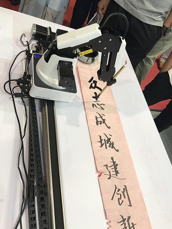 机械臂拿着毛笔写对联。 本文图均为 澎湃新闻记者 王心馨 虞涵棋图