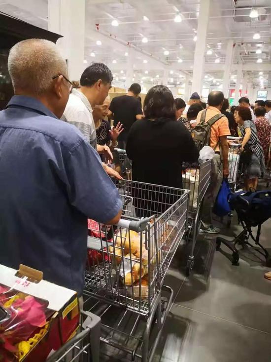 Costco门店内,长长的结账队伍,不少老人在推车