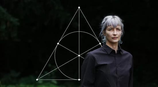 剑桥大学的数学物理学家Cohl Furey正在寻找粒子物理标准模型和八元数之间的联系。八元数的乘法规则被编码在被称为法诺面的三角图中。(摄影:Susannah Ireland)