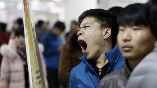 头图丨2016年2月24日,西安,人才市场里人潮涌动,一位求职者打起了哈欠。©视觉中国