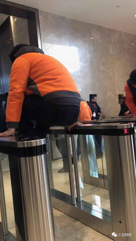 一名维权员工正翻越门闸