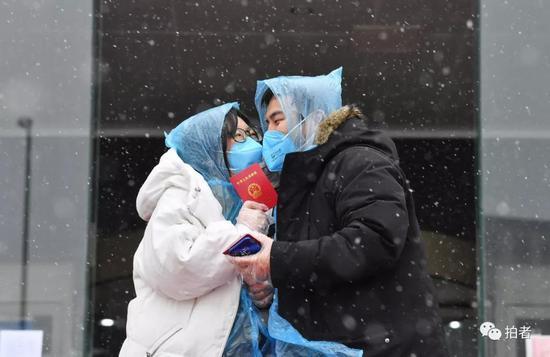 北京市朝阳区民政局婚姻登记处,领完结婚证隔着口罩接吻的新人。图/新京报拍者