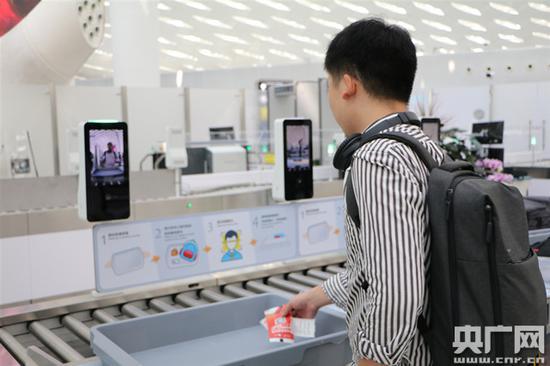 旅客自助取用盛物筐放置随身行李物品(央广网发 通讯员邢恺琳 摄)