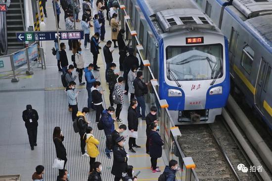 3月24日,西二旗地铁站,站内乘客自觉保持一定距离排队候车。