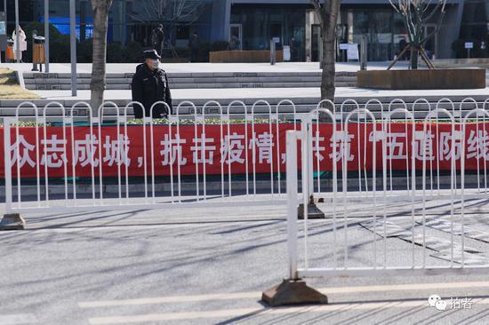 3月13日,西二旗中关村软件园,互联网公司大楼前的防疫宣传标语与安保人员。