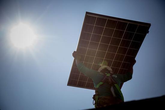 图7:SolarCity员工手举太阳能板