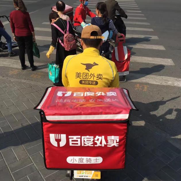 载着百度外卖箱子的美团外卖骑手。不同平台的骑手见面会互相问好,是交流公司的薪金变动情况,伺机而动,路上遇到困难也会相互帮衬。图片来源:网络