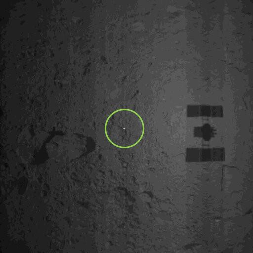 “隼鸟2号”释放到“龙宫”小行星表面,用于指引采样降落的明亮反光“信标物”,图像中还可以看到“龙宫”的影子