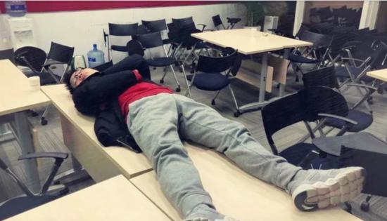 一位同学躺在桌子上睡觉,被无情偷拍