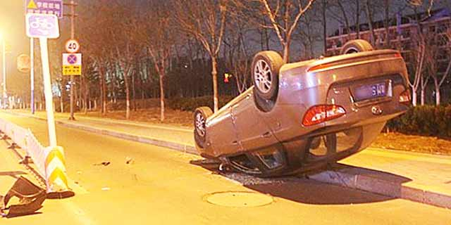 轿车撞栏翻车 底朝天躺人行道