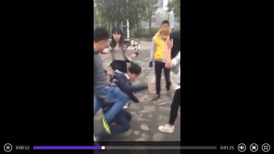视频中,两名女子对余某(跪地上)进行殴打。(视频截图)