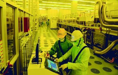 工人们正在无尘车间操作设备生产高品质液晶面板