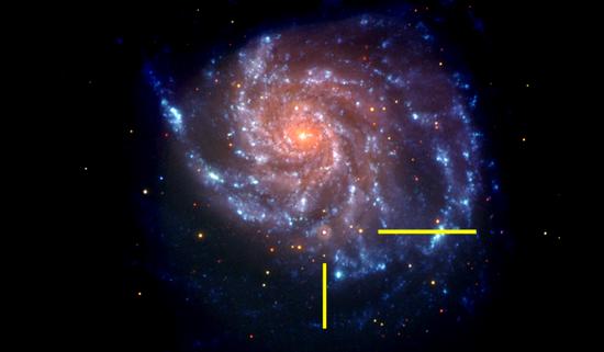 可见光和紫外线下,Swift卫星拍摄的M101星系照片,黄色线代表超新星SN2011fe的位置。照片是伪彩色的,蓝色表示紫外线部分,红色表示可见光部分。