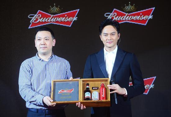 百威英博华南事业部总裁周臻先生为张智霖颁发百威坚持大使和专属的榉木礼盒