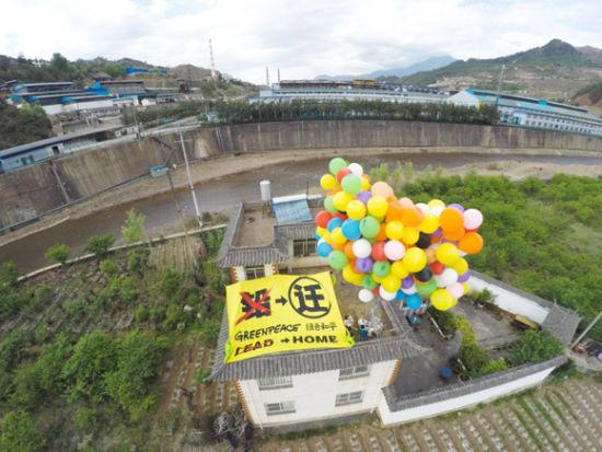 绿色和平调查员通过气球“飞屋”的装置概念,呼吁当地政府尽快将临近村庄搬离污染重地,还给村民一个无毒家园。摄影:Greenpeace/Young